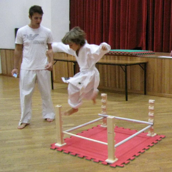 Bambino salta un ostacolo durante l’allenamento
